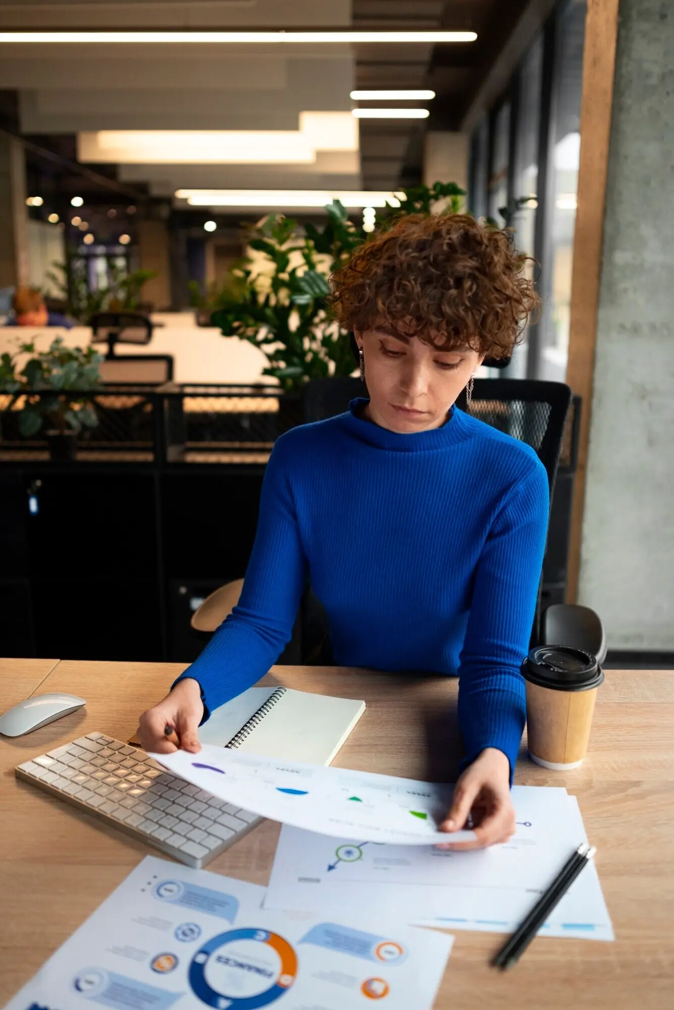 Eine Person im Büro analysiert und prüft Finanzdiagramme.